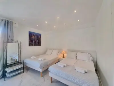 a bedroom with two twin beds and a couch at Velasquez Martinez Plage in Cannes