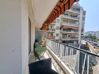 a balcony with a table and a view of a building at Velasquez Martinez Plage in Cannes