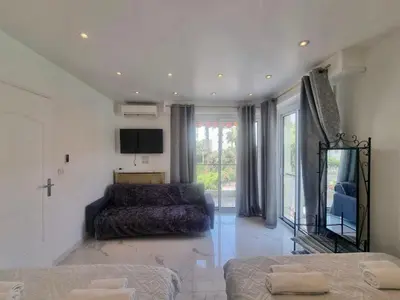 a living room with a bed and a tv at Velasquez Martinez Plage in Cannes