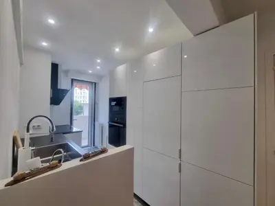a white kitchen with white cabinets and a sink at Velasquez Martinez Plage in Cannes