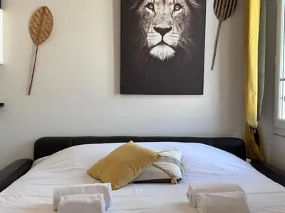 a bedroom with a bed with a picture of a lion at Studio lumineux, Centre ville, Palais Festivals in Cannes
