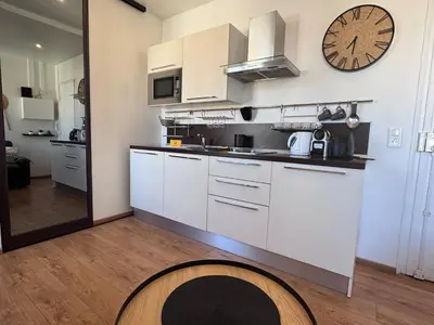 a kitchen with white cabinets and a clock on the wall at Studio lumineux, Centre ville, Palais Festivals in Cannes