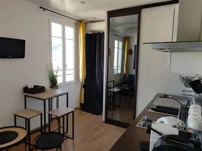 a kitchen with stools and a table and a mirror at Studio lumineux, Centre ville, Palais Festivals in Cannes