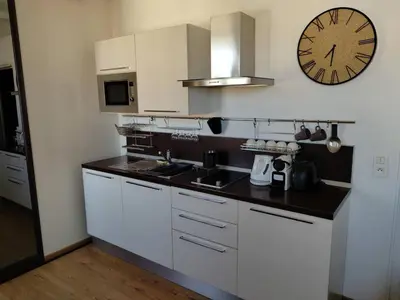 a kitchen with white cabinets and a clock on the wall at Studio lumineux, Centre ville, Palais Festivals in Cannes
