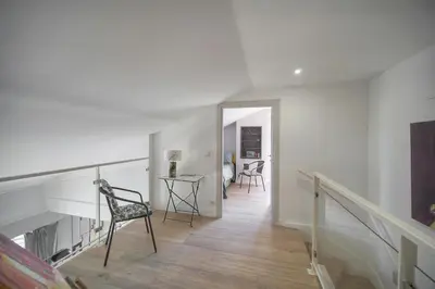 a white hallway with a chair and a table at FRGK Air-Conditioned Duplex with Terrace Secure Residence & Premium Amenities in Cannes