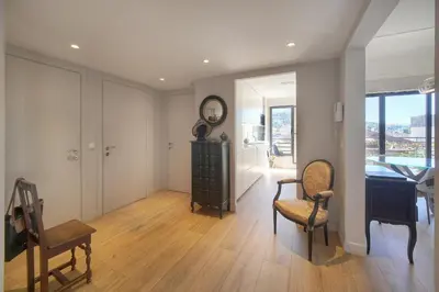 a living room with a clock and a desk and chairs at FRGK Air-Conditioned Duplex with Terrace Secure Residence & Premium Amenities in Cannes