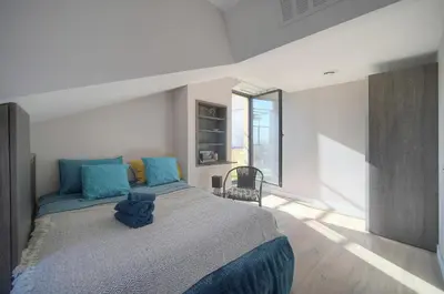 a bedroom with a large bed with blue pillows at FRGK Air-Conditioned Duplex with Terrace Secure Residence & Premium Amenities in Cannes
