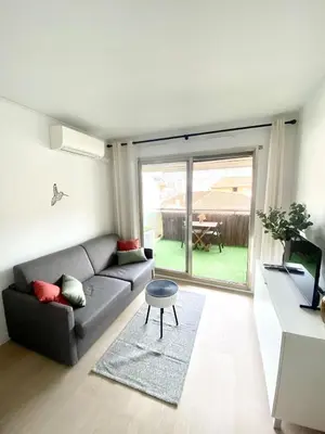 a living room with a couch and a table at Le Cocon - City centre - Terrace - AC - Cosy in Cannes