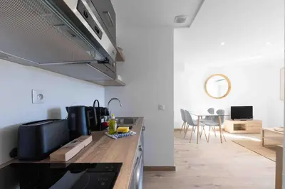a kitchen with a counter and a dining room at Charme au Suquet 1 Chambre & Canapé-Lit AC in Cannes