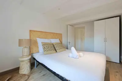 a bedroom with a large bed with white sheets and pillows at Charme au Suquet 1 Chambre & Canapé-Lit AC in Cannes