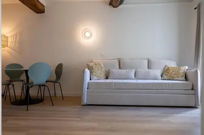 a living room with a white couch and a table at Charmant 2 pièces cœur du Suquet Proche Palais in Cannes