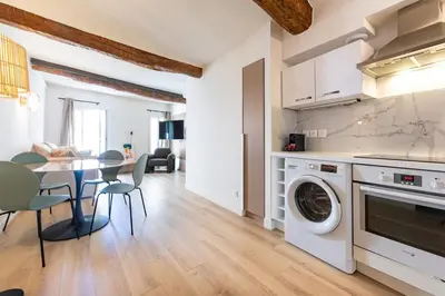 a kitchen and dining room with a table and a washing machine at Charmant 2 pièces cœur du Suquet Proche Palais in Cannes