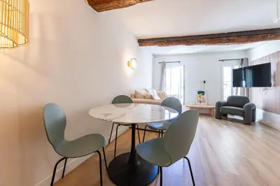 a living room with a table and chairs at Charmant 2 pièces cœur du Suquet Proche Palais in Cannes