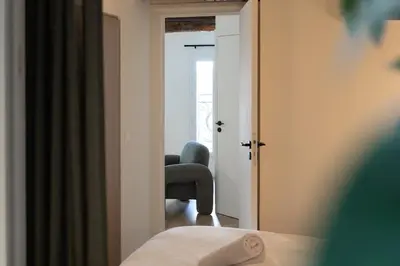 a bedroom with a blue chair and a window at Charmant 2 pièces cœur du Suquet Proche Palais in Cannes