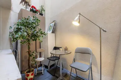 a room with a table and chairs and a lamp at Charmant 2 pièces cœur du Suquet Proche Palais in Cannes