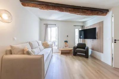 a living room with a couch and a tv at Charmant 2 pièces cœur du Suquet Proche Palais in Cannes