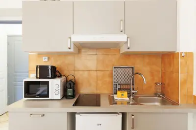 a kitchen counter with a microwave and a sink at Mouette YourHostHelper in Cannes