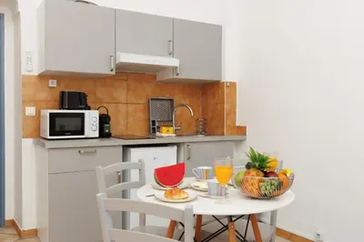 a small kitchen with a table with a bowl of fruit at Mouette YourHostHelper in Cannes