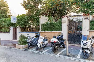 a group of motorcycles parked next to a fence at Mouette YourHostHelper in Cannes