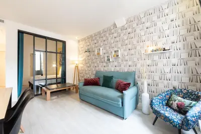 a living room with a blue couch and a chair at Hyper centre spacieux & lumineux proche Palais in Cannes