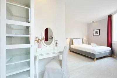 a bedroom with a bed and a desk and a mirror at Hyper centre spacieux & lumineux proche Palais in Cannes