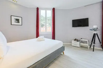 a bedroom with a bed and a television and a camera at Hyper centre spacieux & lumineux proche Palais in Cannes