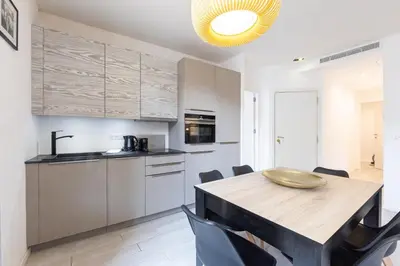 a kitchen and dining room with a wooden table and chairs at Hyper centre spacieux & lumineux proche Palais in Cannes