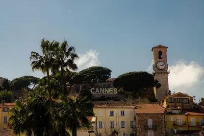 a clock tower on top of a city with a building at Hyper centre spacieux & lumineux proche Palais in Cannes