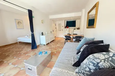a living room with a couch and a table at One-bedroom apt ideally located in front of the Midi beaches in Cannes