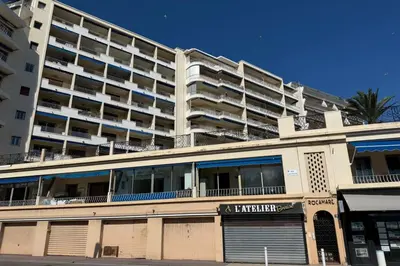 an apartment building with a parking garage in front of it at One-bedroom apt ideally located in front of the Midi beaches in Cannes