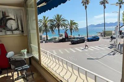 a child walking down a balcony with a view of a street at One-bedroom apt ideally located in front of the Midi beaches in Cannes