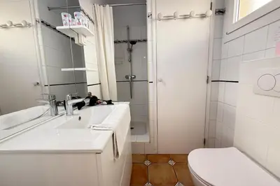 a white bathroom with a sink and a toilet at One-bedroom apt ideally located in front of the Midi beaches in Cannes