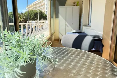 a table with two potted plants on a balcony at One-bedroom apt ideally located in front of the Midi beaches in Cannes