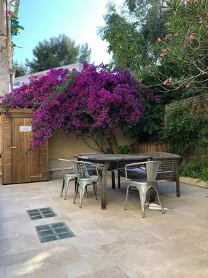 a picnic table and chairs and purple flowers at Sentez-vous comme à la maison près du palais in Cannes