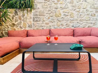 a table with two wine glasses on it in front of a couch at Sentez-vous comme à la maison près du palais in Cannes