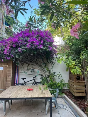 a wooden table with purple flowers on a wall at Sentez-vous comme à la maison près du palais in Cannes