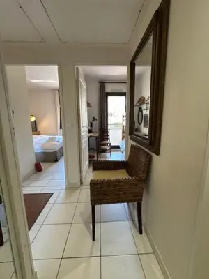 a hallway with a chair and a mirror and a bedroom at Congress et Comfort in Cannes