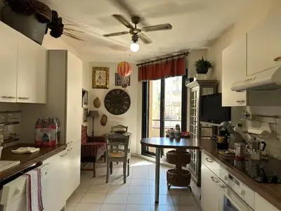 a kitchen with a table and a living room at Congress et Comfort in Cannes
