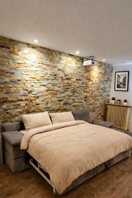 a bedroom with a large bed and a brick wall at Private Pool House , 10min Cannes in Le Cannet