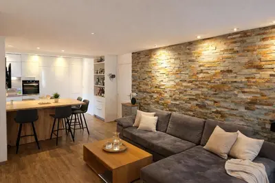 a living room with a couch and a brick wall at Private Pool House , 10min Cannes in Le Cannet