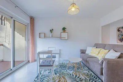 a living room with a couch and a table at Studio avec balcon et parking proche plages in Cannes