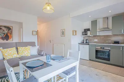 a living room with a couch and a table with chairs at Studio avec balcon et parking proche plages in Cannes