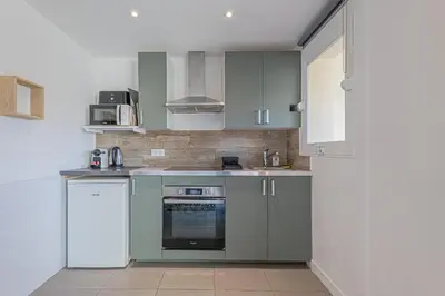 a kitchen with gray cabinets and a sink and a stove at Studio avec balcon et parking proche plages in Cannes
