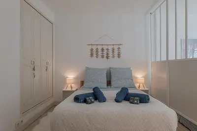 a bedroom with a large bed with blue pillows at Le Bleu Ciel - Studio Croisette idéal congrès in Cannes
