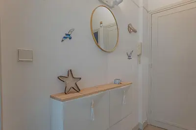 a bathroom with a mirror and a shelf on a wall at Le Bleu Ciel - Studio Croisette idéal congrès in Cannes