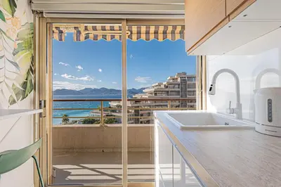 a kitchen with a view of the ocean at Elégant 2 pièces - accès mer direct vue splendide in Cannes