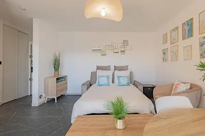 a bedroom with a bed and a couch and a table at Elégant 2 pièces - accès mer direct vue splendide in Cannes