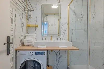 a bathroom with a sink and a washing machine at Elégant 2 pièces - accès mer direct vue splendide in Cannes