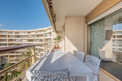 a balcony with a table and chairs and a building at Elégant 2 pièces - accès mer direct vue splendide in Cannes