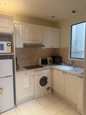 a kitchen with white cabinets and a washing machine at Premium central Apartment in Cannes